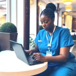 Nurse at a table using a laptop computer