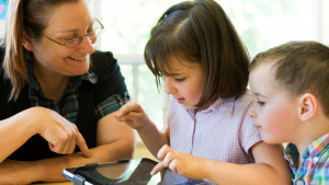 Parent supervising children using tablet