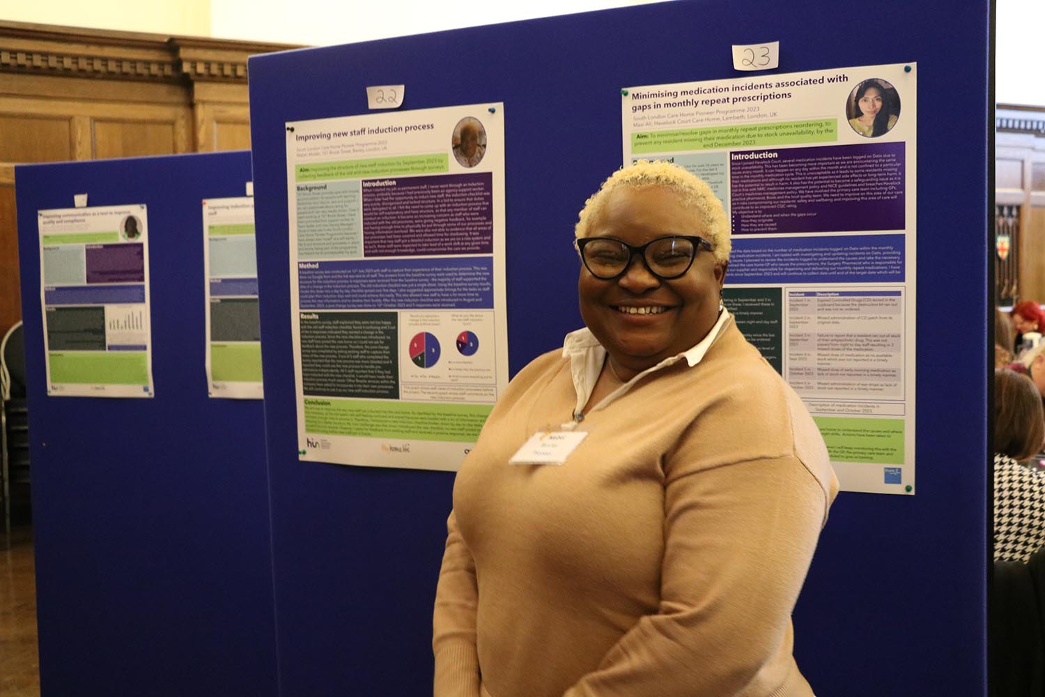 A Pioneer in front of their poster at the December 2023 celebration event